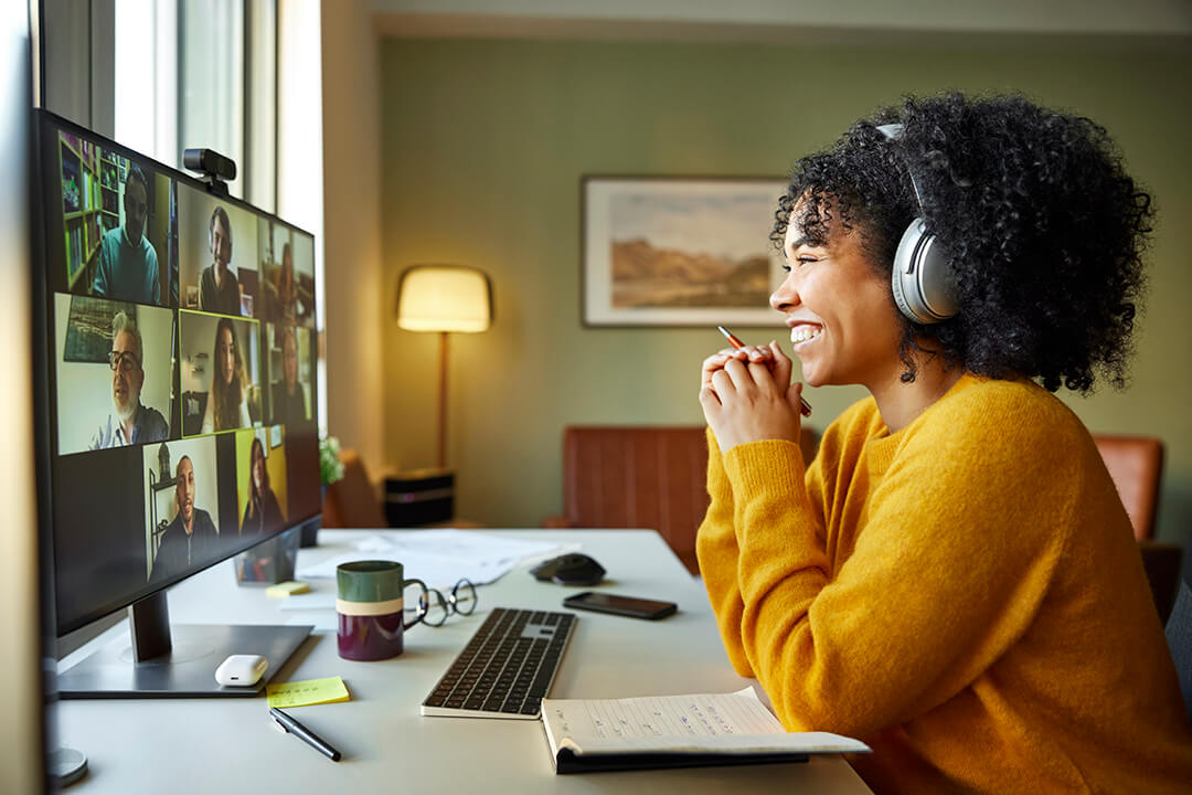 Woman smiling whilst taking a group video call